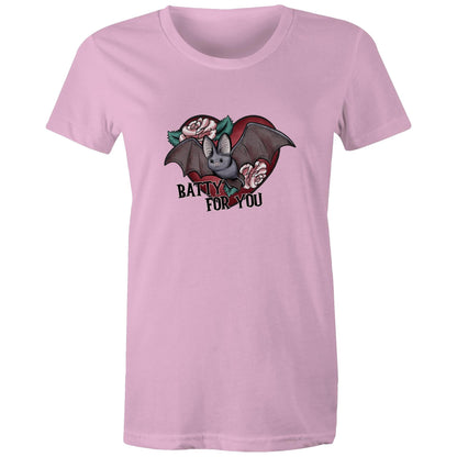 A close-up of a white fabric surface featuring a graphic print of a cute gray bat in front of a red heart, decorated with pink roses and green leaves, with the text 'BATTY FOR YOU' written below in black.