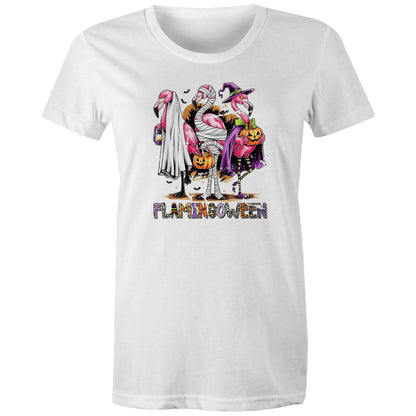 A white t-shirt featuring a colorful graphic of three cartoon flamingos dressed in Halloween costumes. One flamingo wears a white ghost and lantern, another is wrapped in bandages and holds a pumpkin bucket, and the third wears a purple witch hat and cape while holding a jack-o'-lantern.