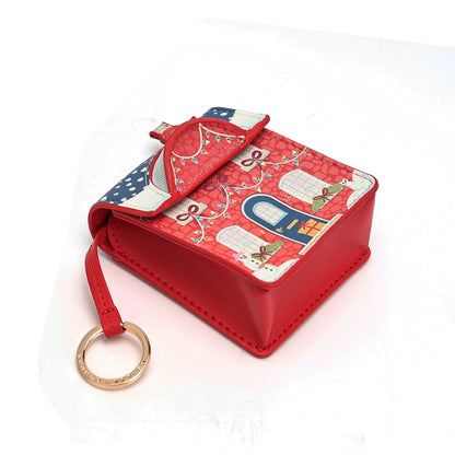 A small red leather key pouch with a decorative holiday-themed patterned flap, featuring a bow detail and a gold-tone key ring, shown on a white background.