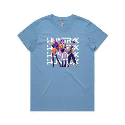 A close-up of a t-shirt featuring a graphic print of three stylized female characters in colorful outfits, overlaid with the word 'HUNTER' repeated vertically in bold white letters.