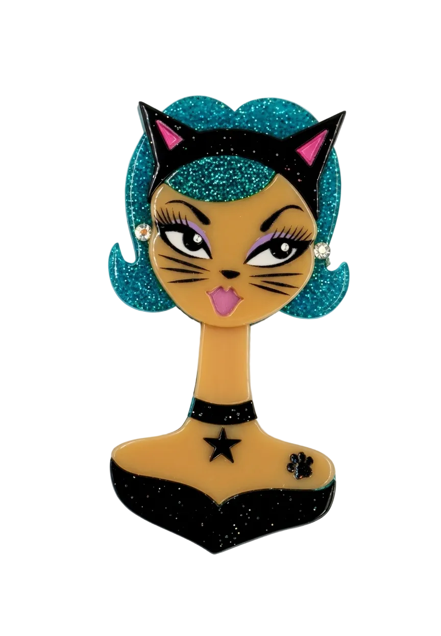 A stylized cartoon cat bust charm or pin with glittery teal hair, black cat-ear headband, tan face and neck, black collar with star, and a black bust-shaped lower section on a plain white background.