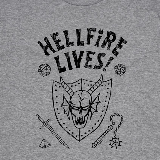 A close-up of a heather gray t-shirt featuring a black graphic print with the text 'HELLFIRE LIVES!' above a horned skull, dice, sword, and mace design.