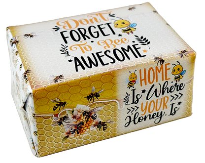 A square gift box with a honeybee-themed design, featuring the text 'Don't Forget To Bee Awesome' and 'Home Is Where Your Honey Is'. The box has a white top with a honeycomb pattern, yellow honeycomb panels on the sides, illustrated bees, flowers, and bumblebees, and is photographed on a clean white background.