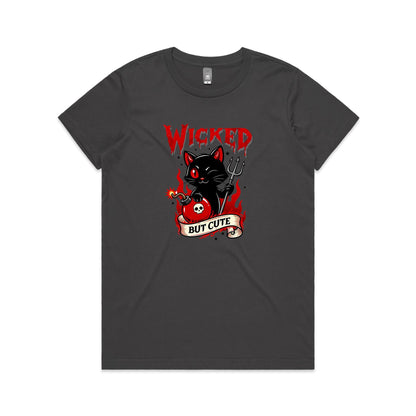 A dark gray t-shirt featuring a graphic print of a cute black cat with red eyes holding a pitchfork and a red bomb with a skull emblem, under the word 'WICKED' and above a banner reading 'BUT CUTE'.