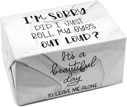 A square white gift box wrapped in crinkled white paper with black printed text. The top reads 'I'M SORRY DID I JUST ROLL MY EYES OUT LOUD?' and the front reads 'It's a beautiful day TO LEAVE ME ALONE'.