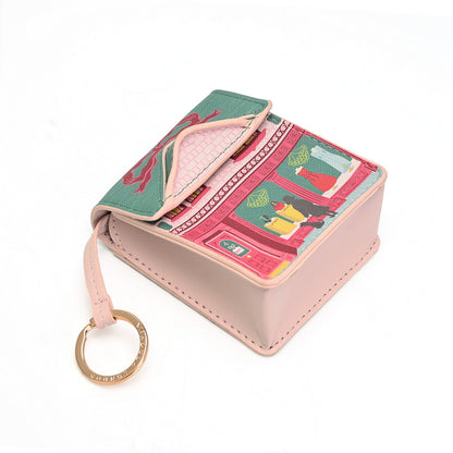 A small pink card holder wallet with a colorful printed pattern on the flap and a gold-tone key ring, shown on a white background.