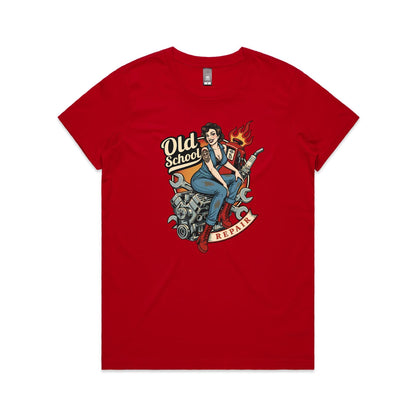 A vintage-style pin-up illustration printed on a white garment, showing a woman in blue overalls and red boots sitting on a motorcycle engine with wrenches, a gas pump, flames, and the words 'Old School' and 'REPAIR'.