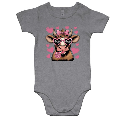 A stylized cartoon cow face with brown and cream fur, pink heart-shaped sunglasses, a pink bow on its horns, and a pink lollipop, surrounded by pink hearts on a light pink background.