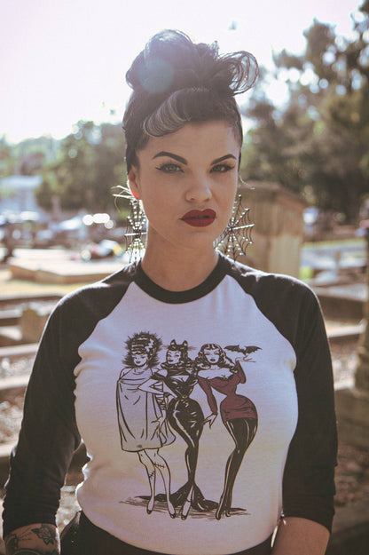 Woman wearing a black and white baseball shirt with a graphic design outdoors.