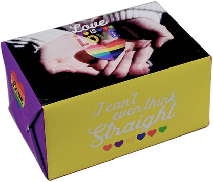 A rectangular gift box with a yellow front panel and purple side panel, printed with the phrase 'I can't even think Straight' in white script and small rainbow hearts. The top lid shows a photo of two hands holding a rainbow-striped heart, with the word 'Love' overlaid.
