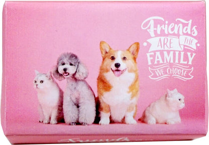 A pink rectangular box featuring a printed design of four pets—a white cat, a gray poodle, a corgi, and a white kitten—along with the text 'Friends ARE THE FAMILY WE CHOOSE' in white script and banner fonts.