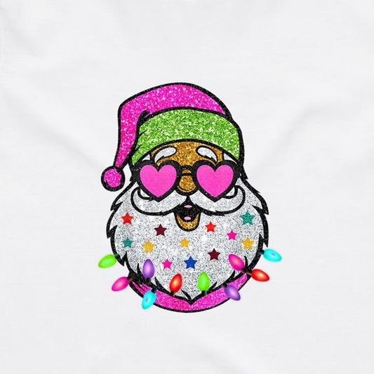 A festive embroidered Santa face design on a white fabric background. The Santa figure has a glittery pink Santa hat, heart-shaped pink glasses, a white beard decorated with colorful stars, and colorful Christmas lights around the bottom.
