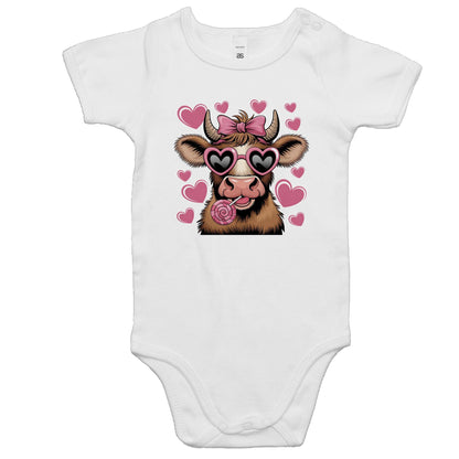 A pink baby onesie romper with a print of a cartoon cow with hearts and sunglasses on it.