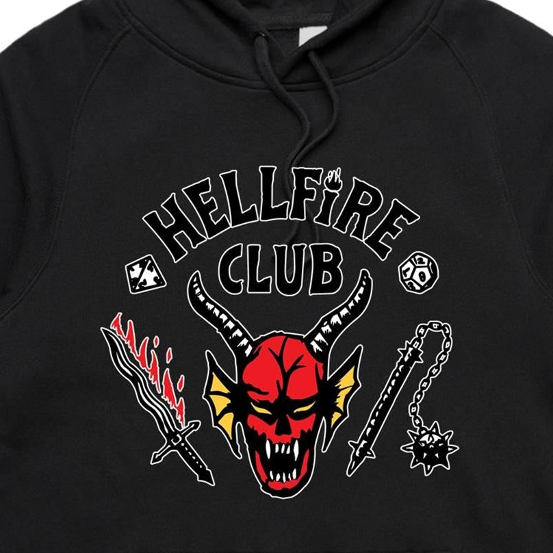 Close-up of a black hoodie featuring a graphic print with the words 'HELLFIRE CLUB' and a red horned skull surrounded by a sword, flame motif, chain, and skull emblem.