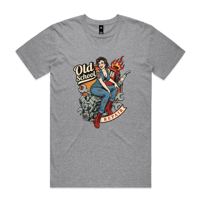A vintage-style pin-up illustration printed on a white garment, showing a woman in blue overalls and red boots sitting on a motorcycle engine with wrenches, a gas pump, flames, and the words 'Old School' and 'REPAIR'.
