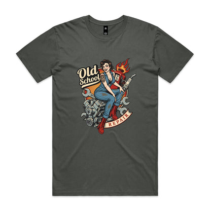 A vintage-style pin-up illustration printed on a white garment, showing a woman in blue overalls and red boots sitting on a motorcycle engine with wrenches, a gas pump, flames, and the words 'Old School' and 'REPAIR'.