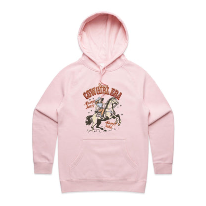 A close-up of a light heather gray hoodie featuring a vintage-style graphic of a cowboy riding a horse, with the text 'In my COWGIRL ERA Always Sassy Always Wild'.