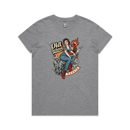 A vintage-style pin-up illustration printed on a white garment, showing a woman in blue overalls and red boots sitting on a motorcycle engine with wrenches, a gas pump, flames, and the words 'Old School' and 'REPAIR'.