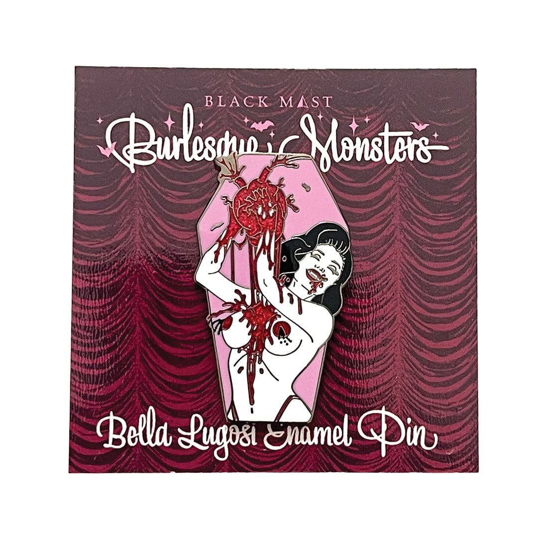 A Black Mast 'Burlesque Monsters' enamel pin of 'Bella Lugosi', shown on its illustrated backing card. The pin depicts a woman in a coffin-shaped casket with a bloody severed heart.