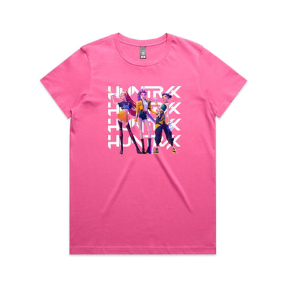 A close-up of a t-shirt featuring a graphic print of three stylized female characters in colorful outfits, overlaid with the word 'HUNTER' repeated vertically in bold white letters.