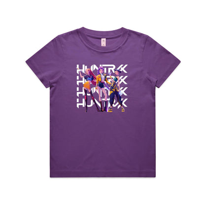 A close-up of a purple t-shirt featuring a graphic print of three stylized female anime characters in colorful outfits, overlaid with the word 'HUNTRX' repeated vertically in large white letters.
