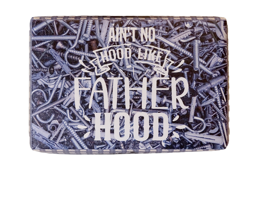 A rectangular metal sign with a distressed, rustic design featuring a background of piled screws and nails in silver and dark gray tones. The text reads 'AIN'T NO HOOD LIKE FATHER HOOD' in stylized white lettering.