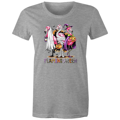 A white t-shirt featuring a colorful graphic of three cartoon flamingos dressed in Halloween costumes. One flamingo wears a white ghost and lantern, another is wrapped in bandages and holds a pumpkin bucket, and the third wears a purple witch hat and cape while holding a jack-o'-lantern.