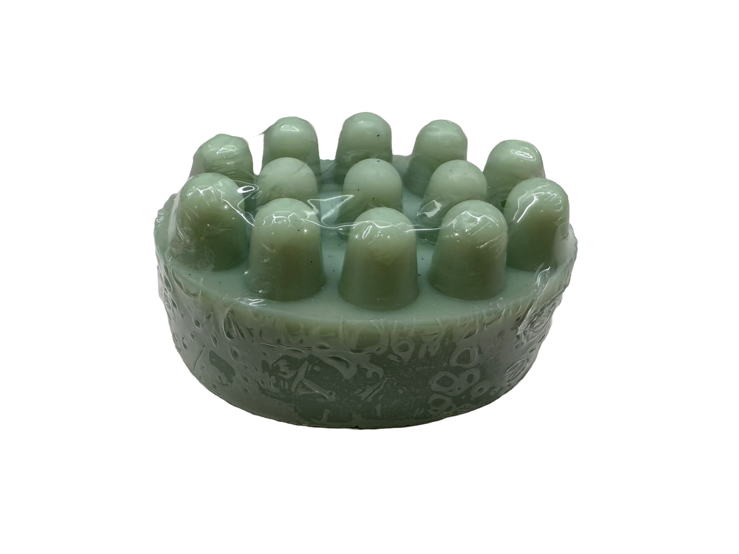 A light green jade-like circular hair massager with multiple rounded massage nodes and an engraved pattern on the side, shown on a plain white background.