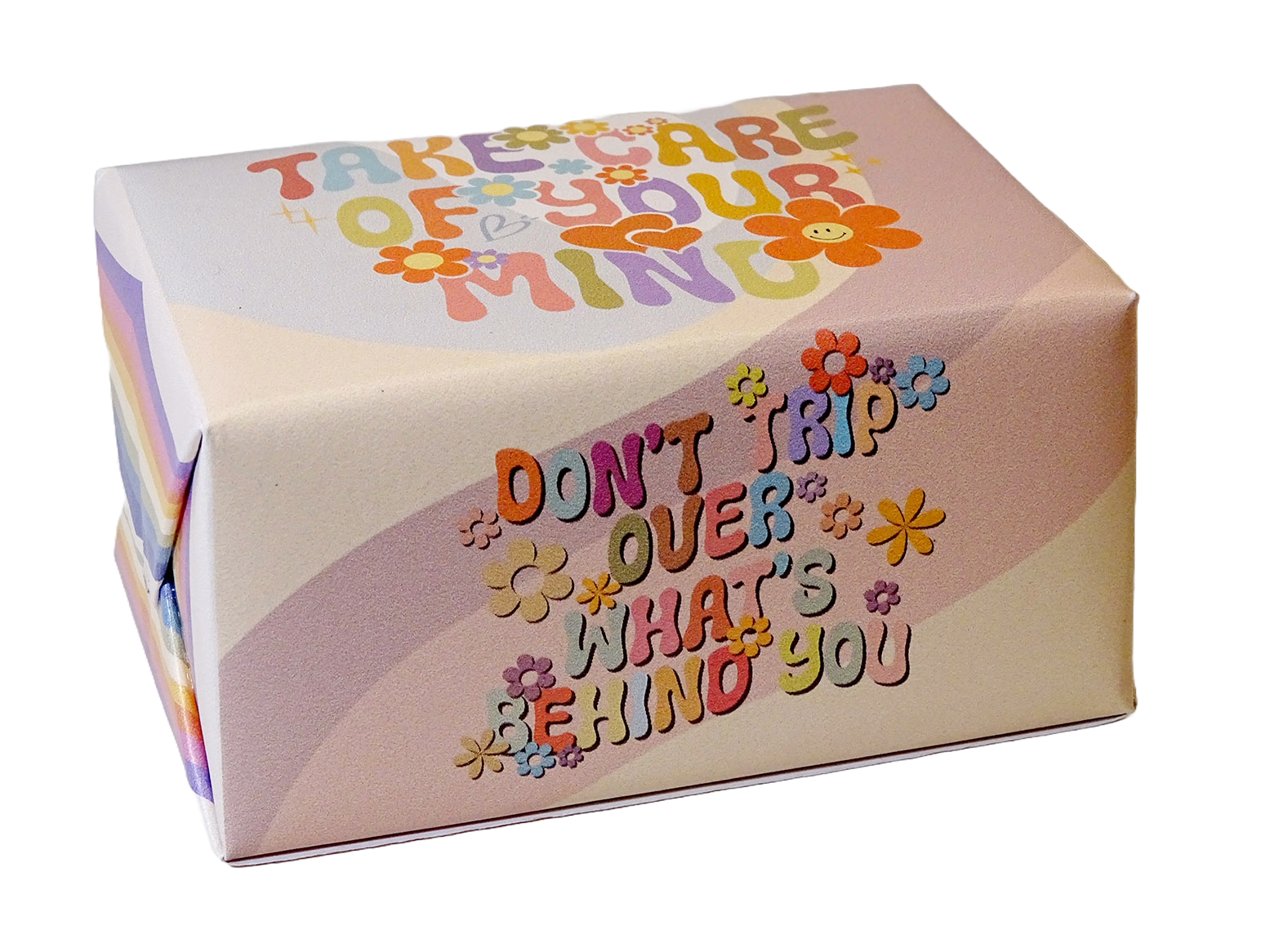 A square gift box with rounded corners featuring retro-style colorful text that reads 'TAKE CARE OF YOUR MIND' and 'DON'T TRIP OVER WHAT'S BEHIND YOU' decorated with small flower illustrations, shown on a plain white background.