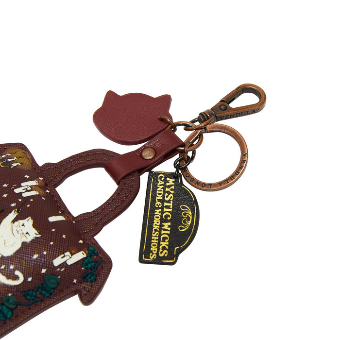 Cat-shaped keychain with a bag design and 'Mystic Wicks' tag on a white background