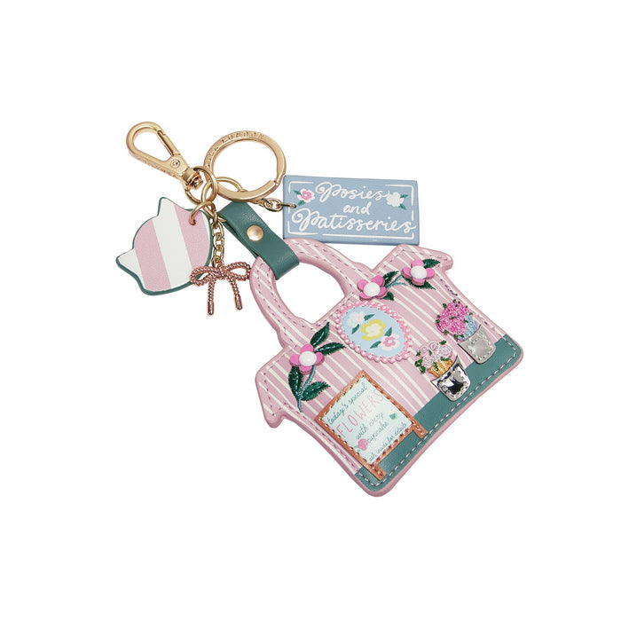 Keychain with pink bag charm and decorative elements on a white background