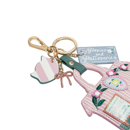 Keychain with pink handbag charm and other accessories on a white background