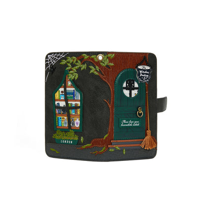 Handbag with treehouse design featuring a door, window, and broomstick on a white background