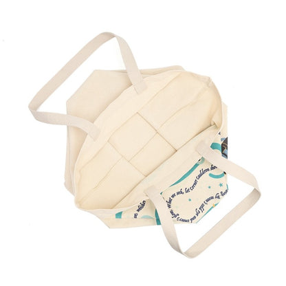 An off-white canvas tote bag with quilted paneling on the front and a printed patterned insert inside, shown on a plain white background.