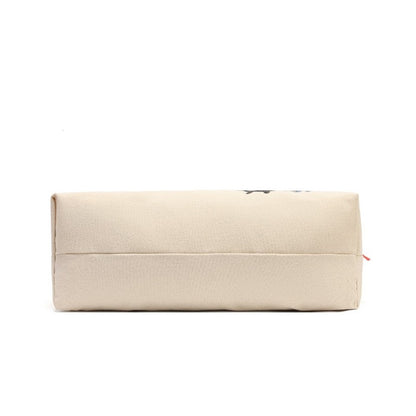 A rectangular canvas pouch in a light beige color, featuring a small black graphic on the top right and a tiny red zipper pull, shown against a plain white background.