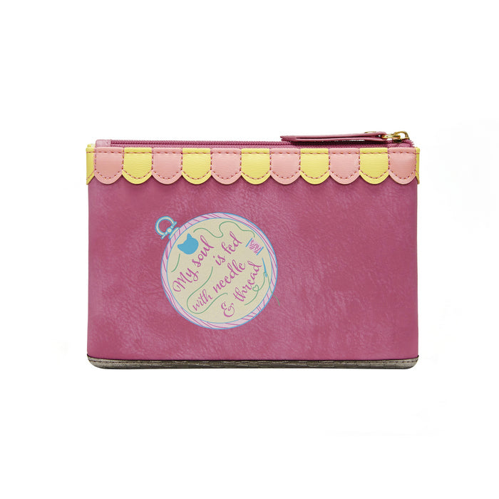 Pink pouch with yellow trim and decorative label on a white background