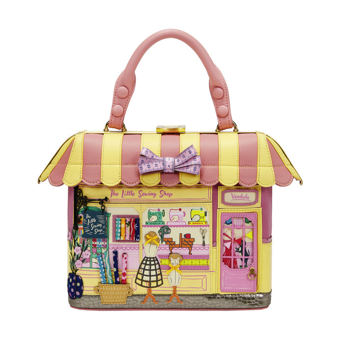 Handbag designed like a store front with colorful graphics and a pink handle on a white background