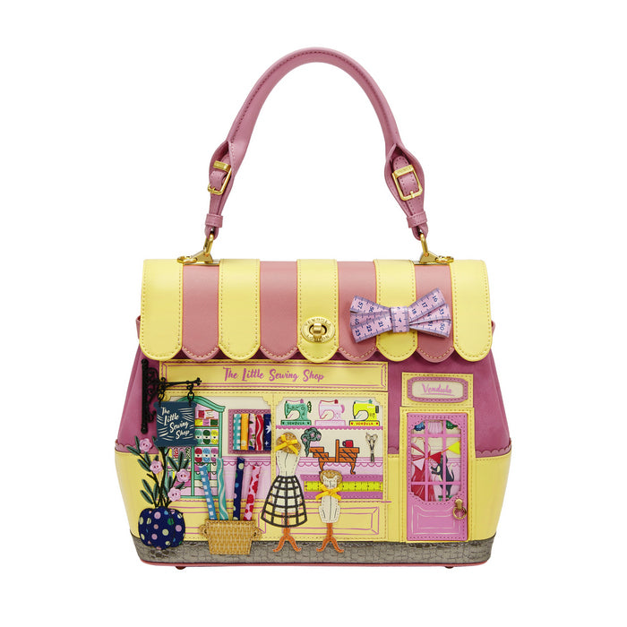 Handbag designed like a store front with a pink and yellow color scheme on a white background