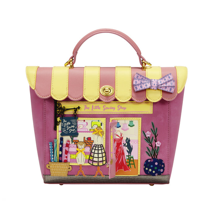 Pink and yellow handbag with decorative elements on a white background