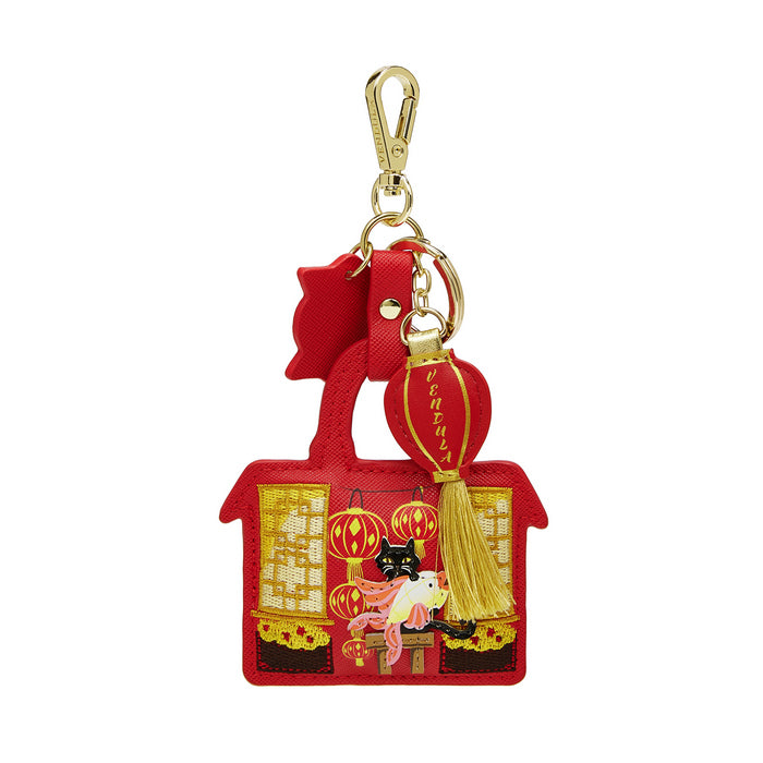 Red house-shaped keychain with gold accents and a cat design on a white background