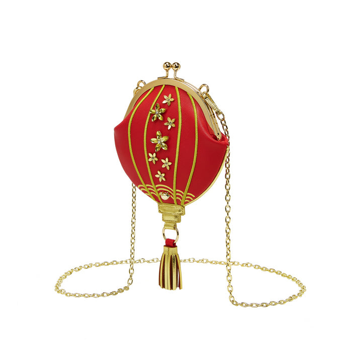 Red lantern-shaped handbag with gold accents on a white background