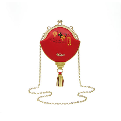 Red handbag with gold chain and tassel on a white background