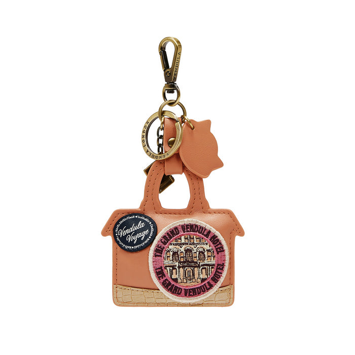 Brown leather luggage-shaped keychain with decorative patches on a white background