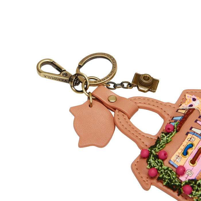 Peach-colored keychain with a camera charm on a white background
