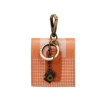 Orange grid-patterned cardholder with gold keychain and camera charm on a white background