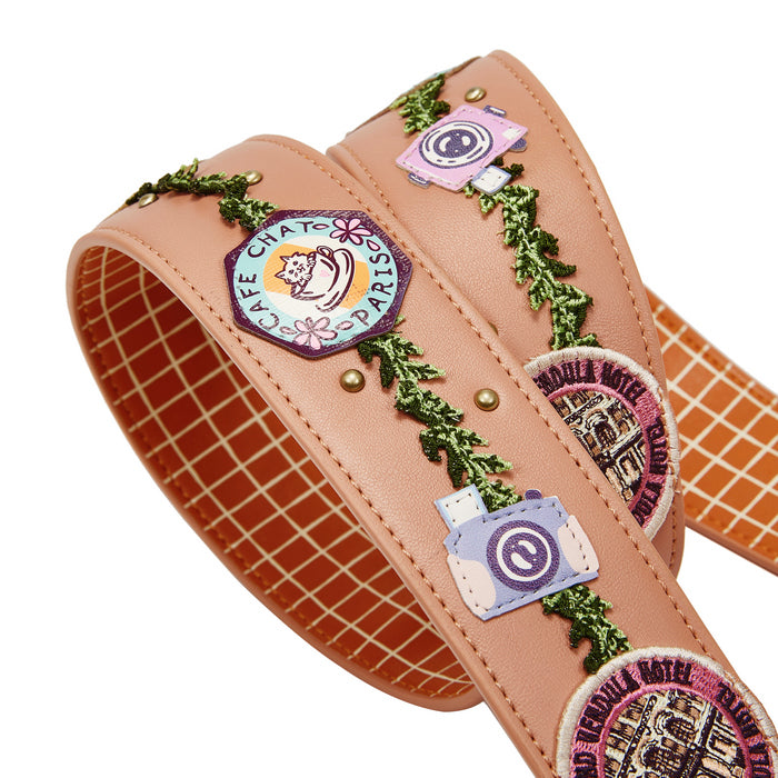 Leather strap with embroidered patches and greenery on a white background