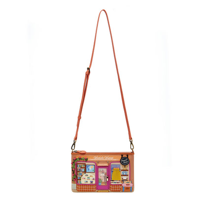 Crossbody bag with a colorful design of a store front on a white background