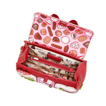 Red suitcase with a pink interior featuring cookie patterns on a white background