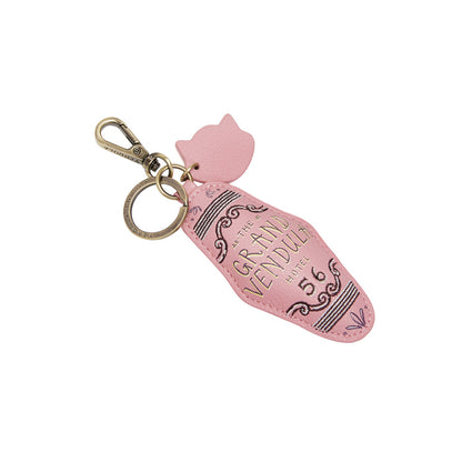 Pink keychain shaped like a bottle with decorative text on a white background