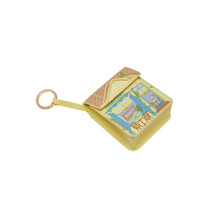 Small yellow box with a keychain attached on a white background